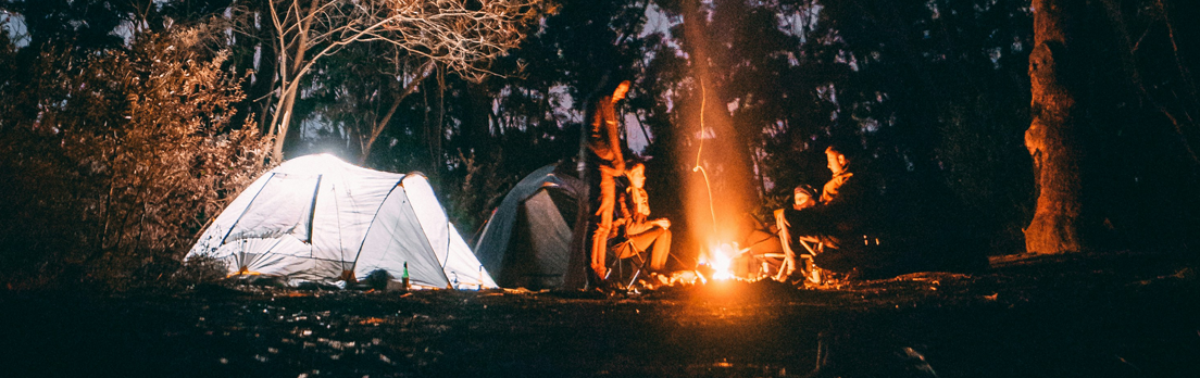 Friends gathering around a fire celebrating our time and making it easy with the best outdoor gear.